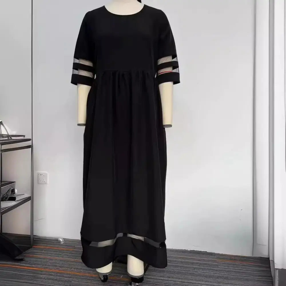 Black midi mesh patchwork dress with three-quarter sleeves, sheer accents, contrasting striped cuffs, and hem band with pockets