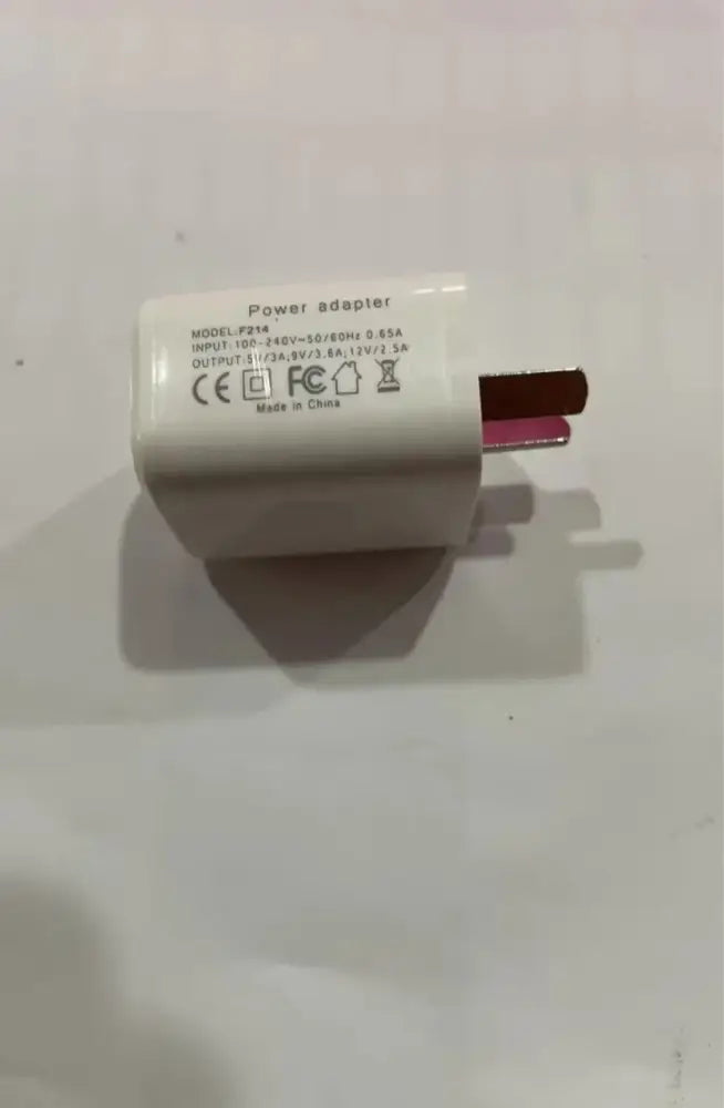 White plastic power adapter with rectangular body and three-pronged plug for g-shaped led lamp with bluetooth speaker and wireless charger