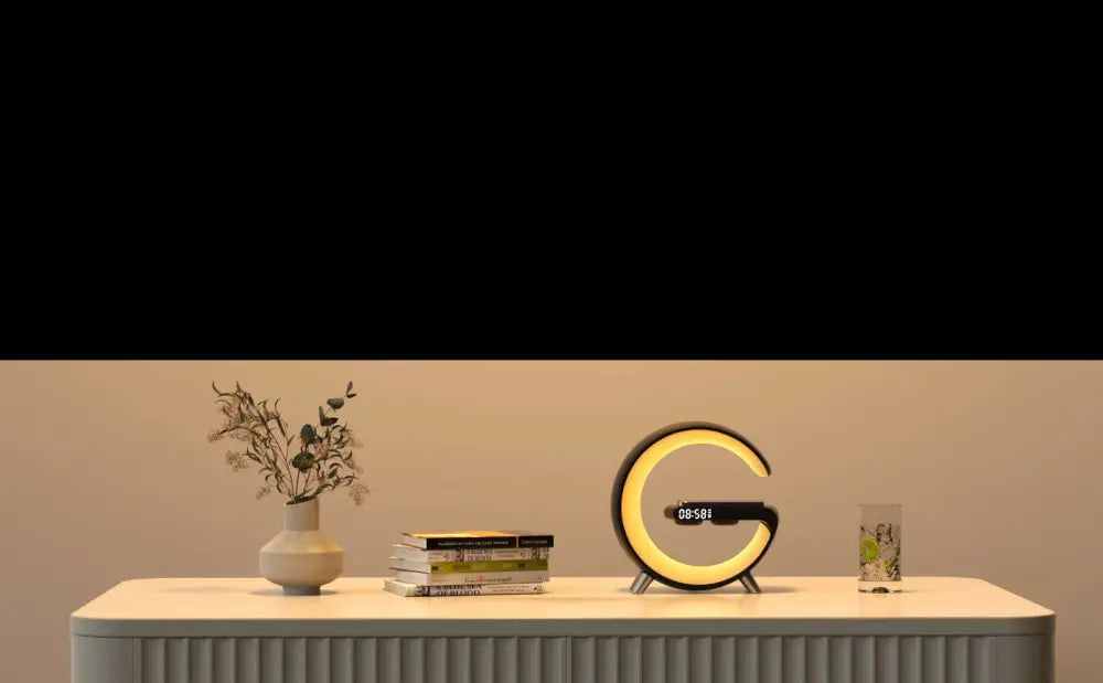 G-shape smart ambient light with bluetooth speaker charger featuring a sleek c-shaped led clock with yellow glow and black base