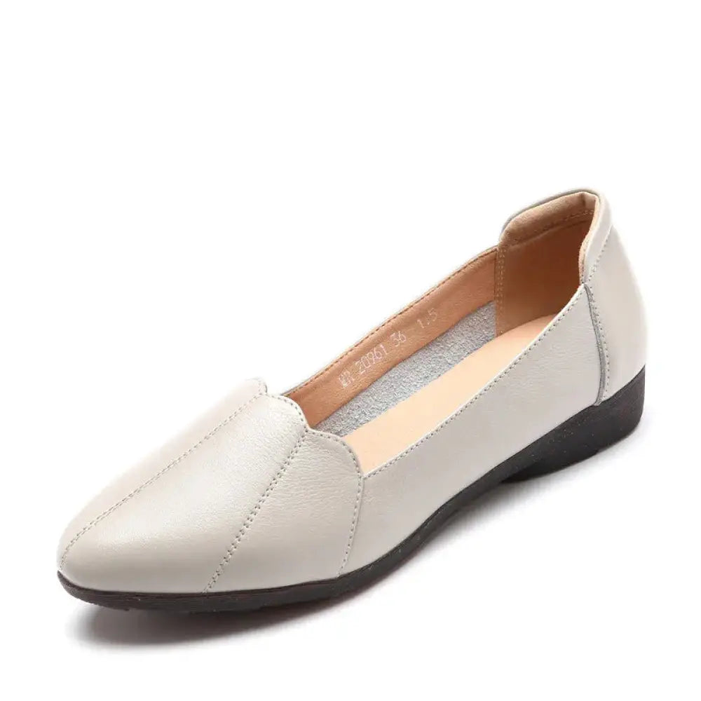 Cream-colored leather loafer with sleek pointed toe and black rubber sole from scalloped beige leather flats collection