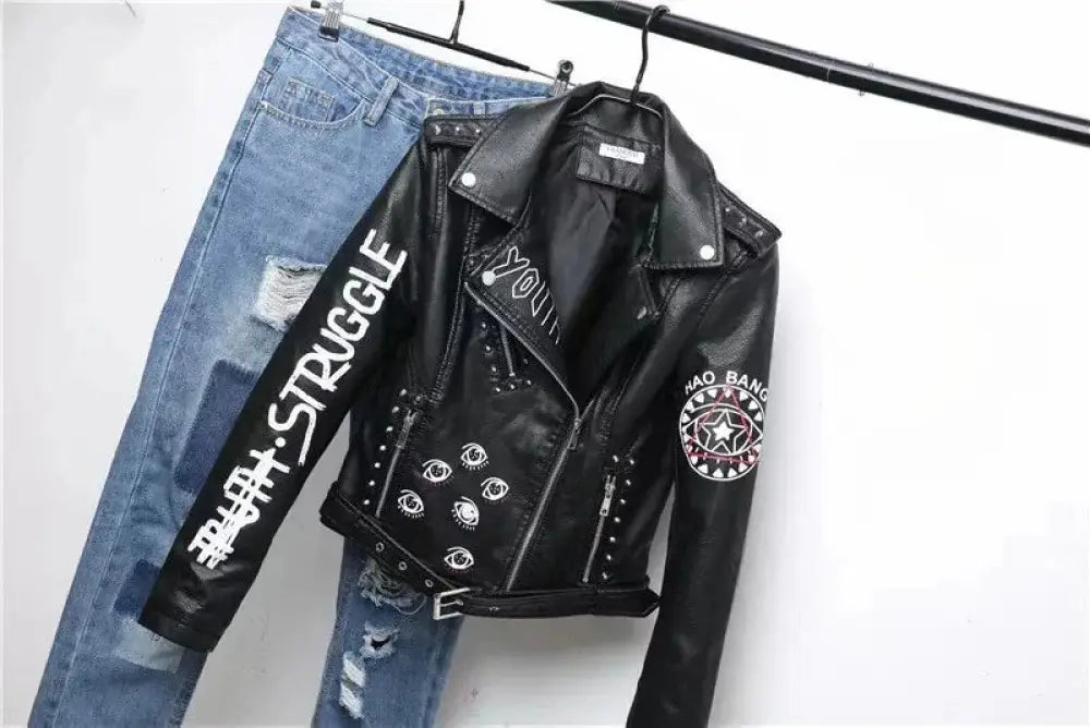 Black faux leather biker jacket with white studded details eye embroidery and a patch on the sleeve