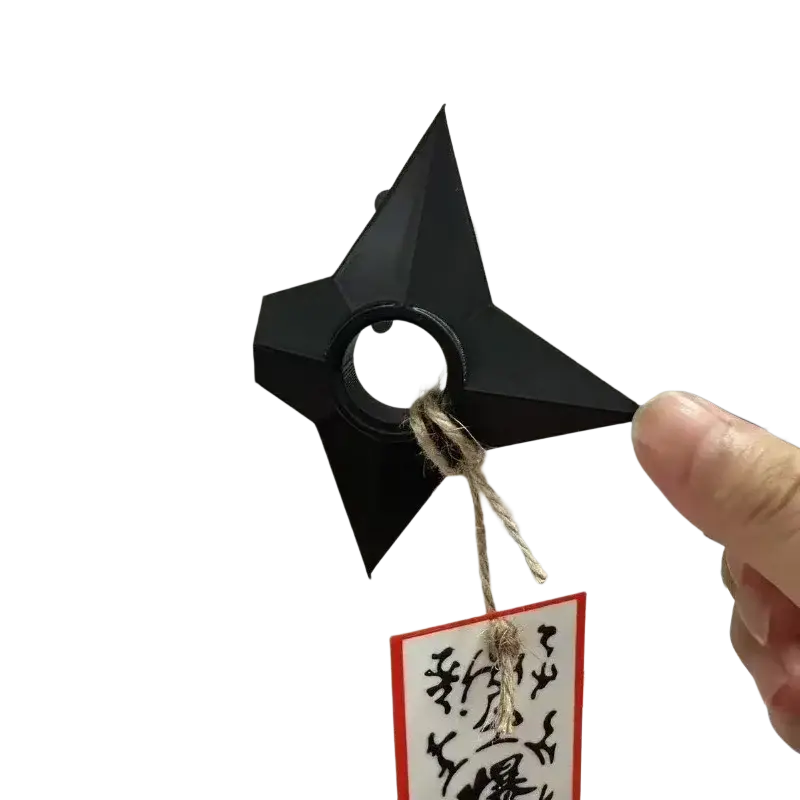 Black plastic ninja kunai fridge magnet shuriken toy with central ring and rough twine tied around the center