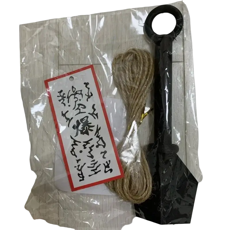 Black plastic shovel with looped handle and bundled natural twine beside ninja kunai fridge magnet pvc shuriken toy