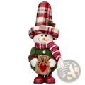 A festive nordic christmas gnome plush figurine dressed in green coat red beige plaid hat and holding a burlap sack