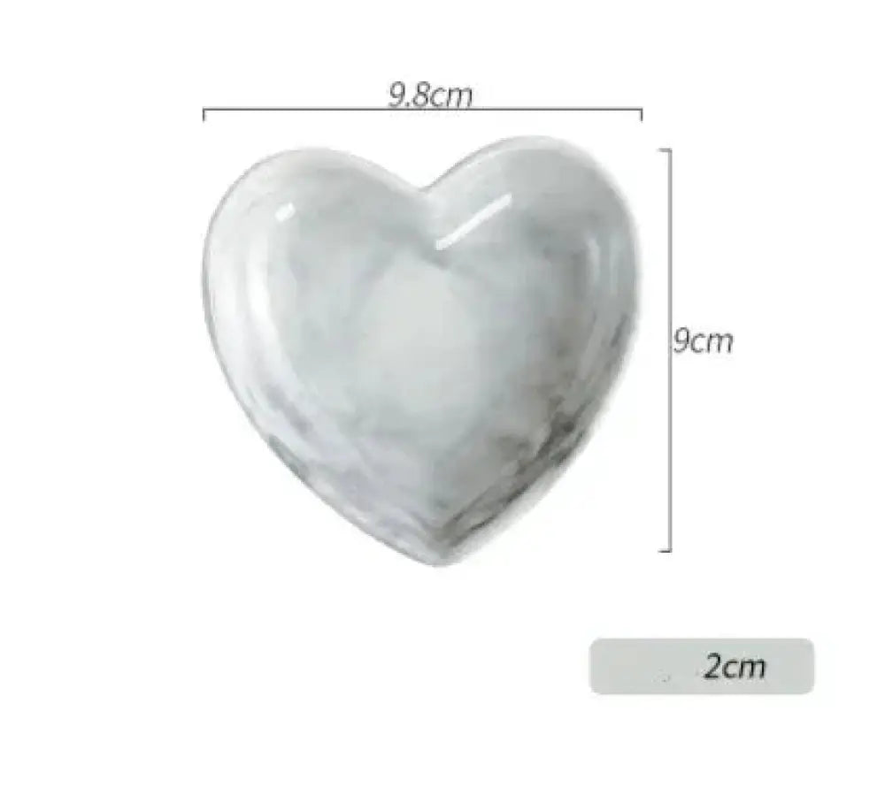 A glossy white and gray marbled heart-shaped ceramic dish from the Nordic marbled heart ceramic dinnerware set