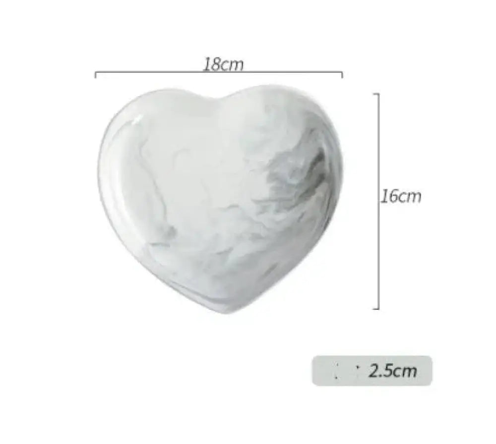 A smooth heart-shaped ceramic coaster with white and gray marble veined pattern from the nordic marbled heart dinnerware set