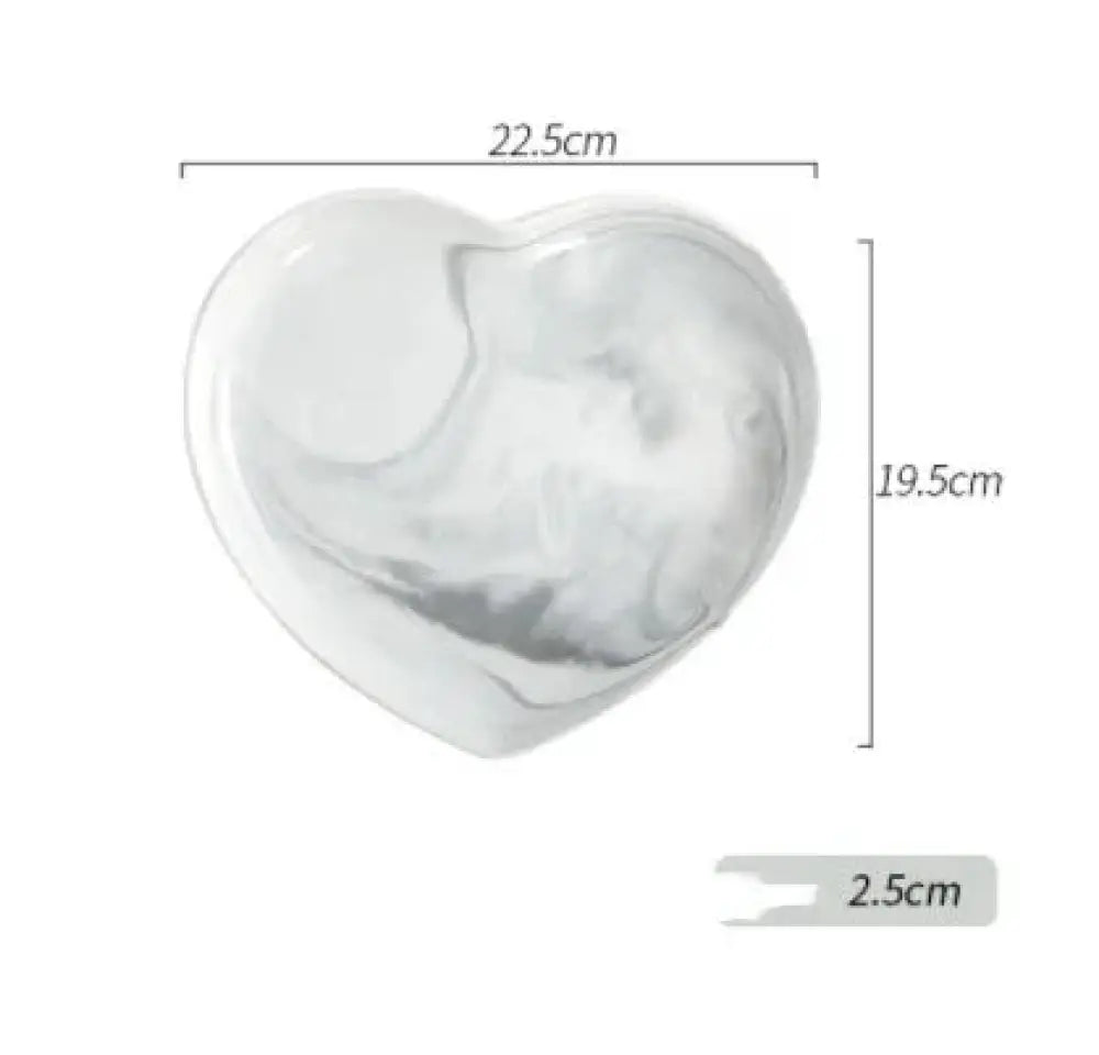 A glossy white heart-shaped ceramic dish with subtle gray marbling from the nordic marbled heart dinnerware set