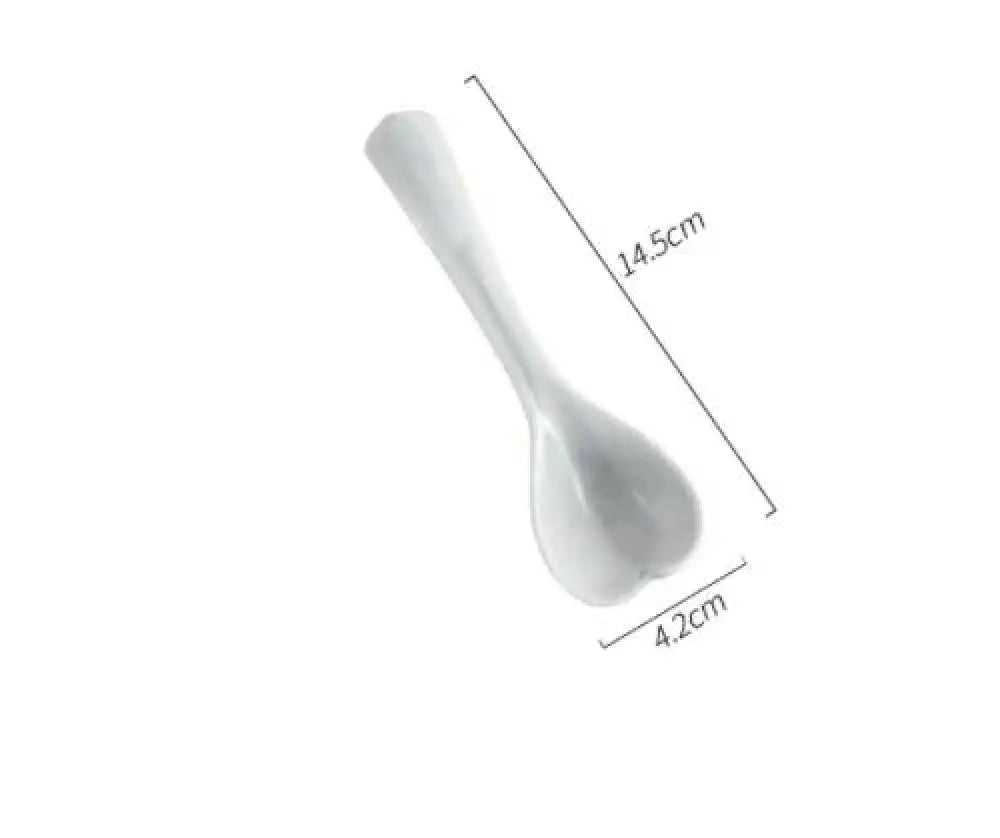 A sleek white ceramic rice spoon with a glossy finish and ergonomic handle from the Nordic Marbled Heart dinnerware set