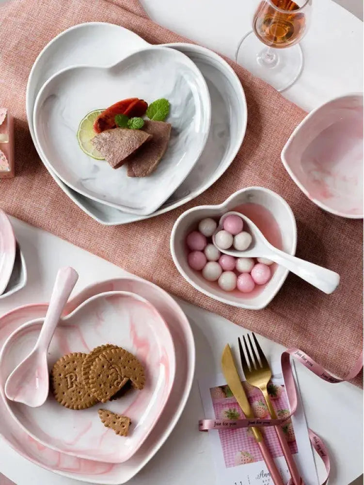 Nordic marbled heart ceramic dinnerware set with soft pink and white plates holding sliced meat garnished with lime and mint