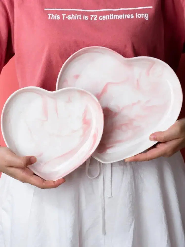 Pair of heart-shaped ceramic plates with soft pink and white marbled design from nordic marbled heart dinnerware set