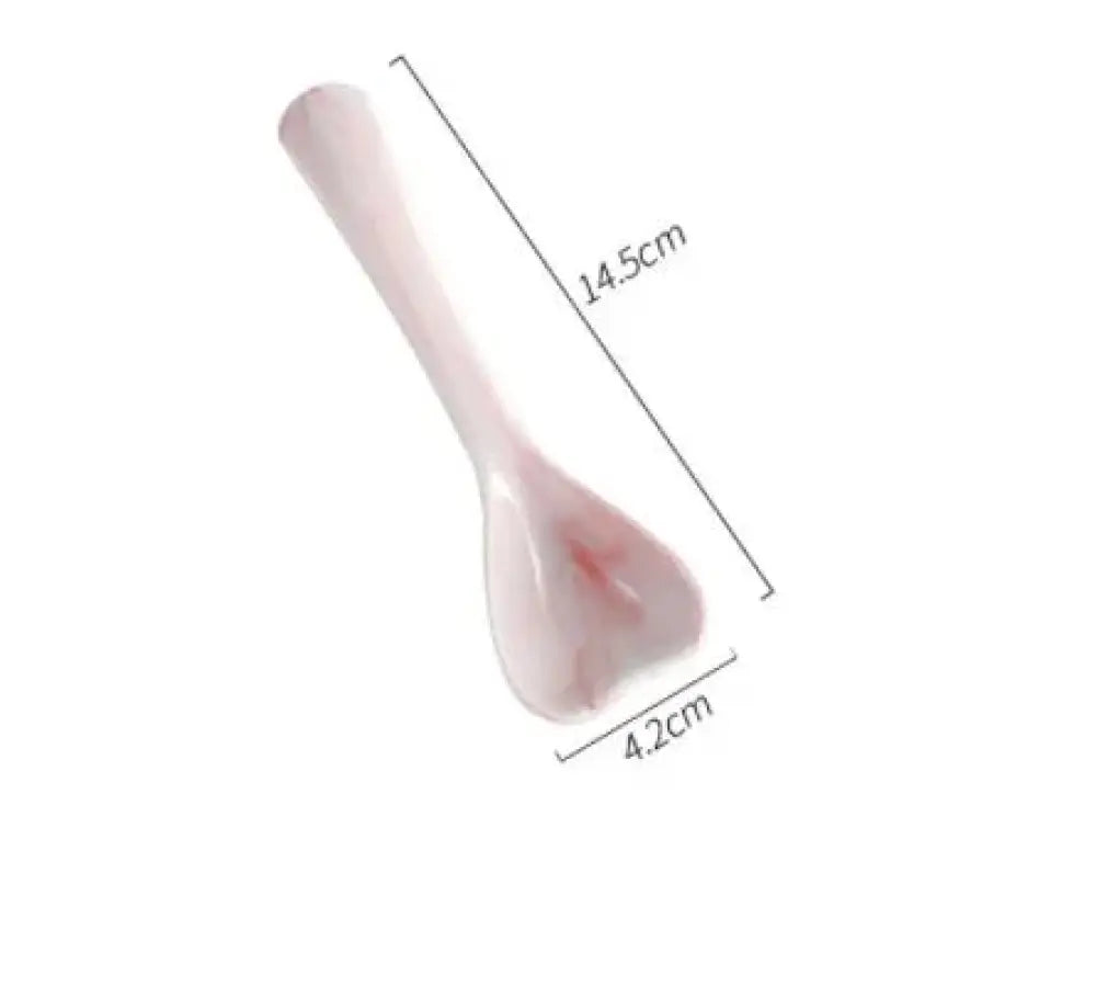 A translucent pink ceramic spoon with a smooth glossy finish and slightly curved handle from Nordic Marbled Heart dinnerware set