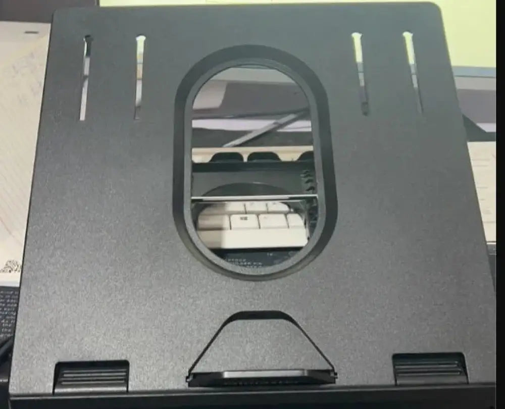 Black adjustable ergonomic folding laptop stand with oval cutout and ventilation slots shown from the back side