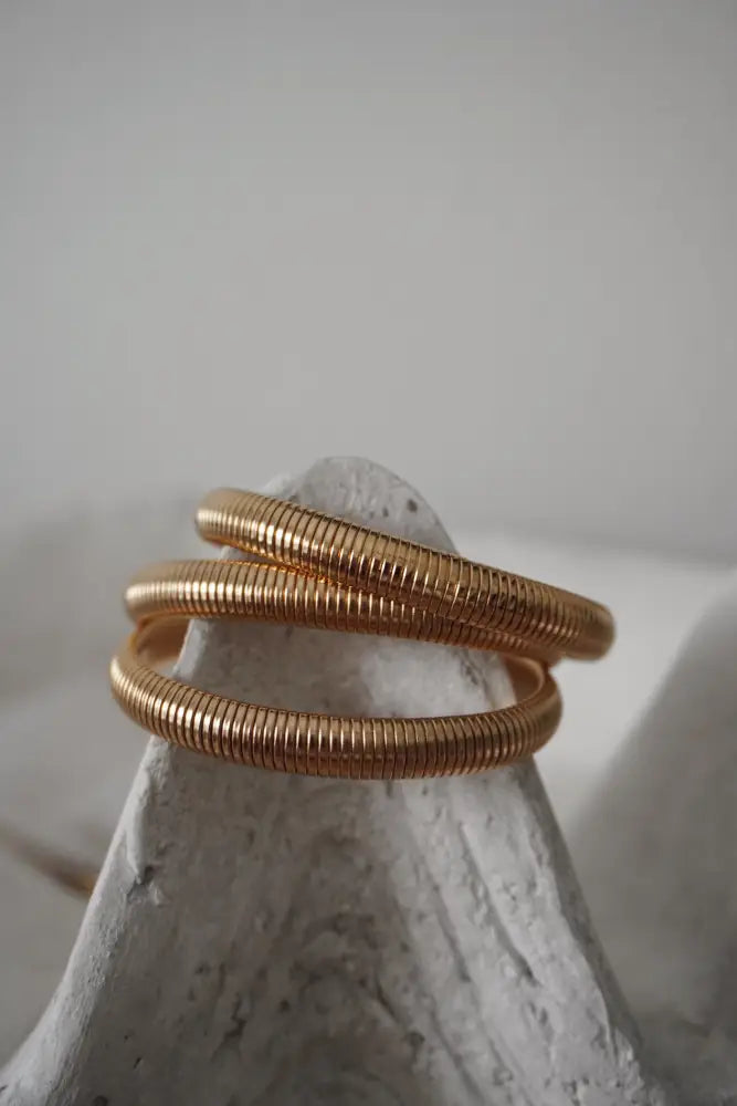 Nova gold ribbed stackable snake bangle bracelet in gold tone with a sleek metallic finish and ribbed texture
