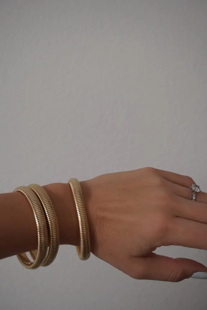 Nova gold ribbed stackable snake bangle bracelet in gold tone with textured ribbed design worn on wrist