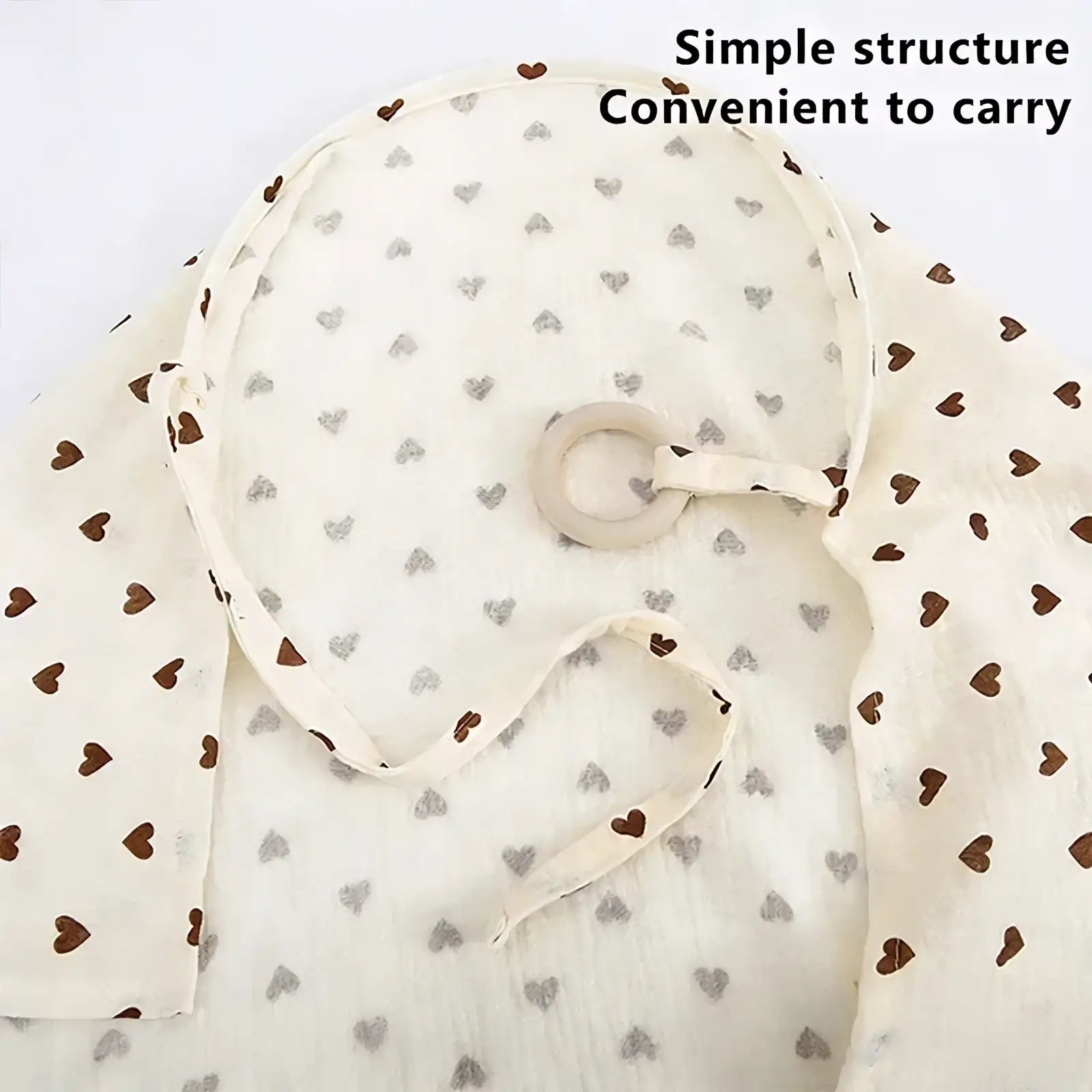 Cream-colored muslin cotton nursing cover with a breathable fabric and subtle brown and gray heart pattern