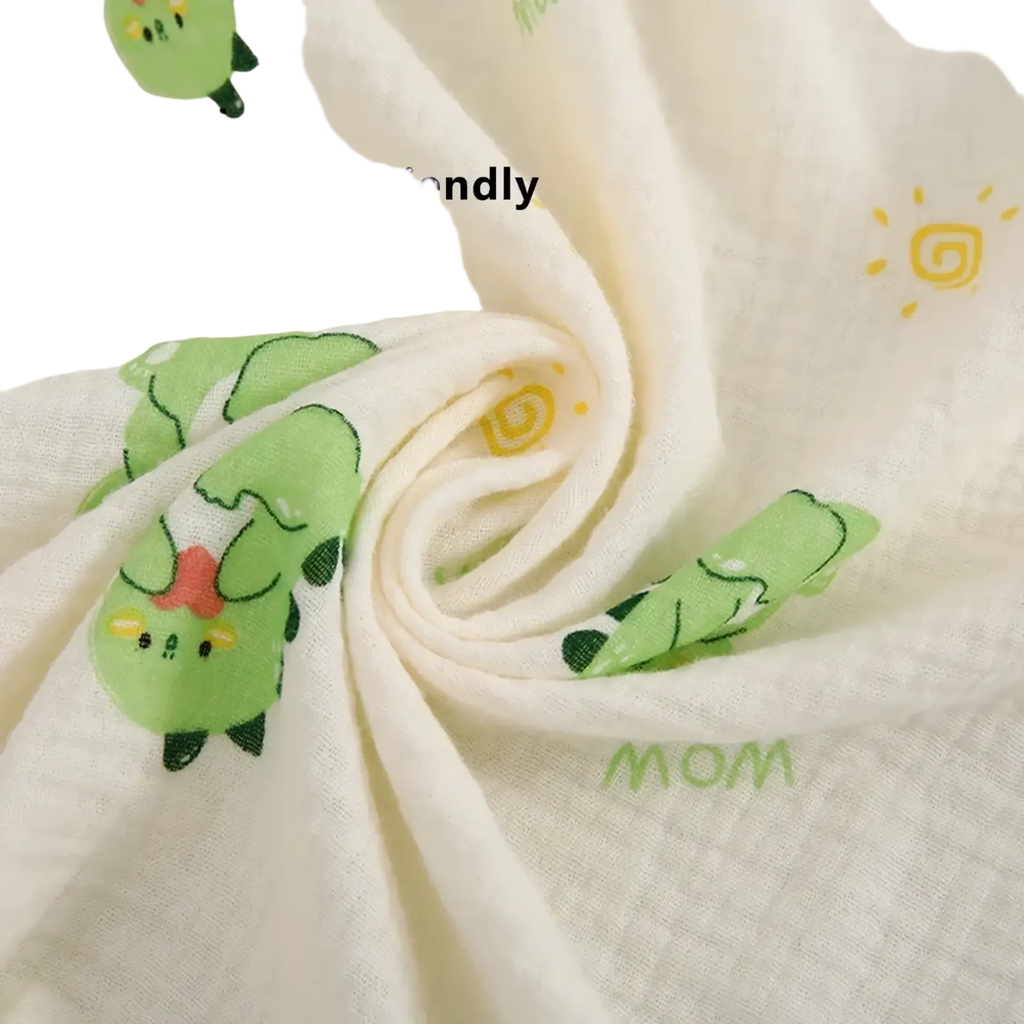 A soft off-white cotton muslin nursing cover featuring a breathable dinosaur print with green and yellow accents