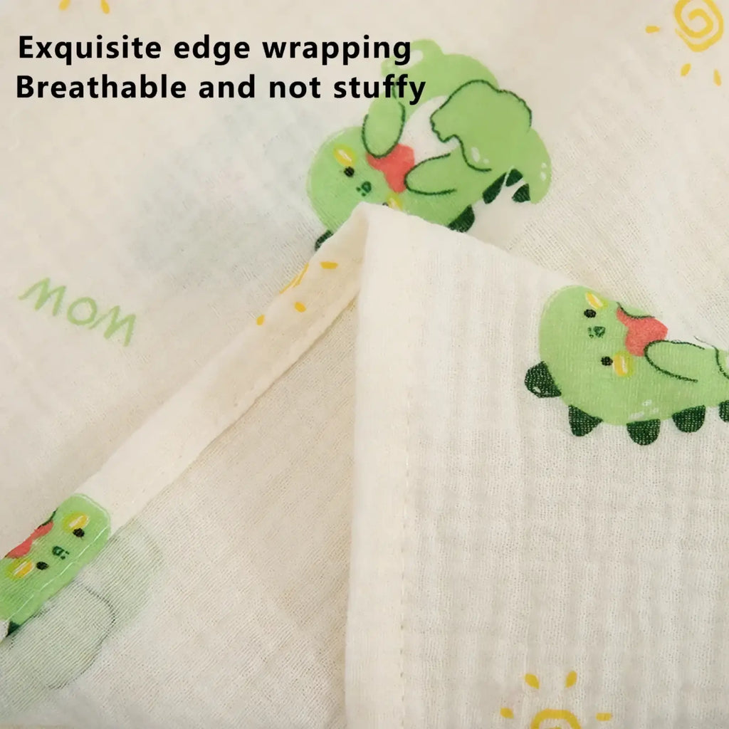 White cotton muslin nursing cover with breathable texture and playful green dinosaur illustrations with red bows