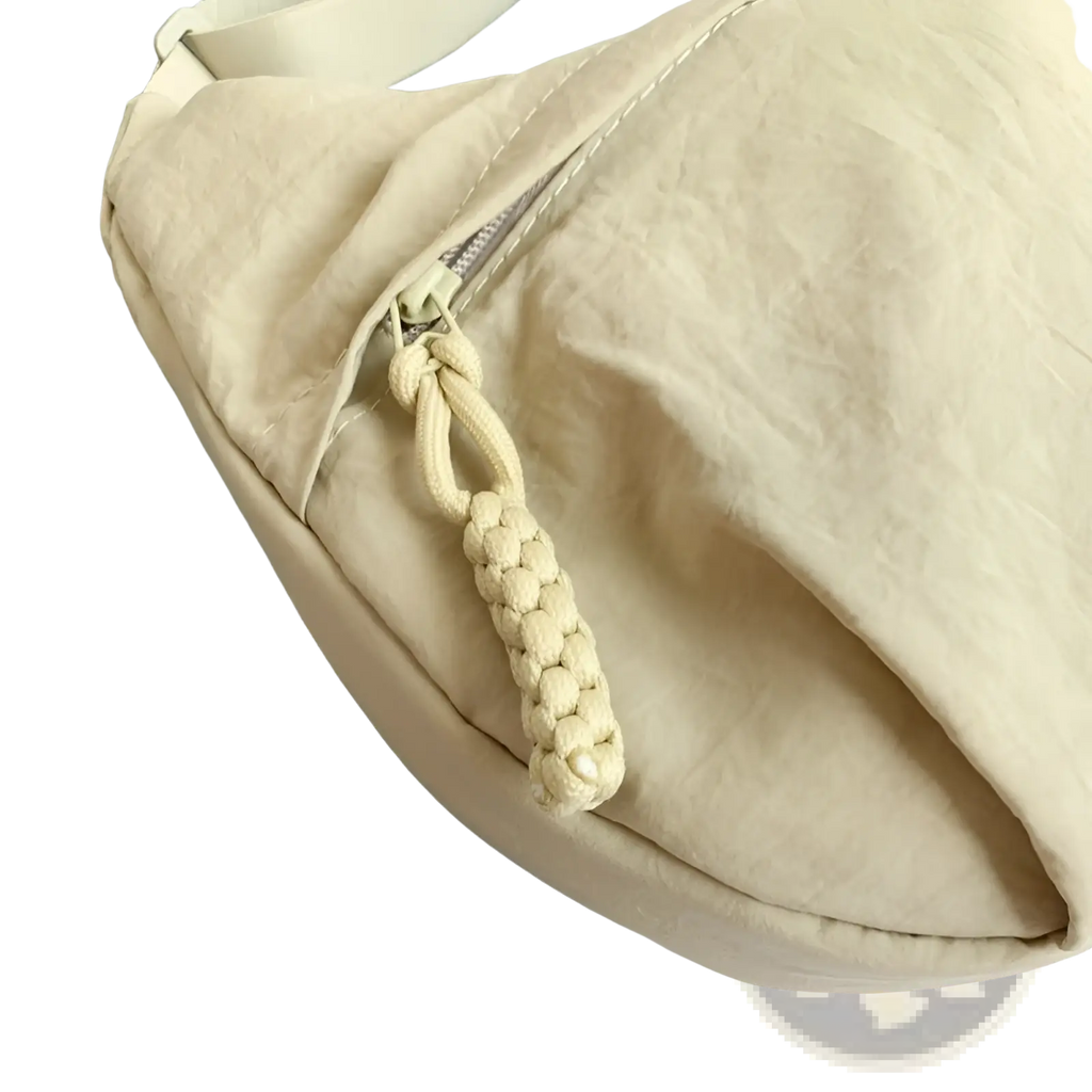 Beige nylon crossbody bag with large capacity and braided cord zipper pull for hobo shoulder use