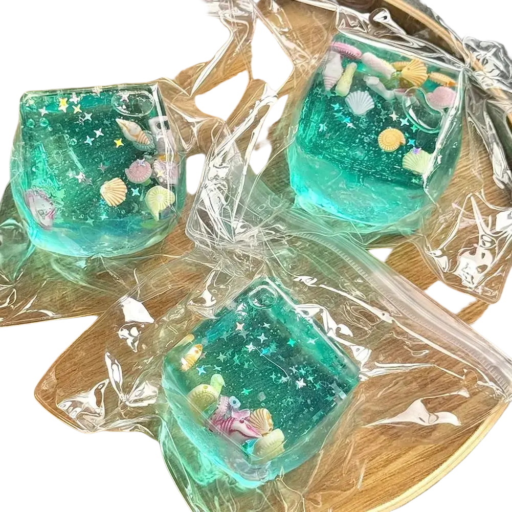 Three translucent teal resin ocean sensory fidget cubes with glittery stars and pastel seashells thoughtful gift