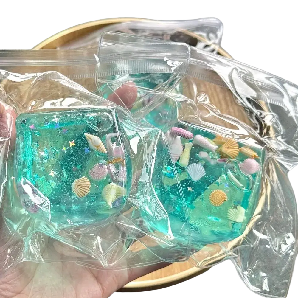 Ocean shell fidget toy squishy cube stress ball in teal and green resin with embedded seashells starfish and glitter