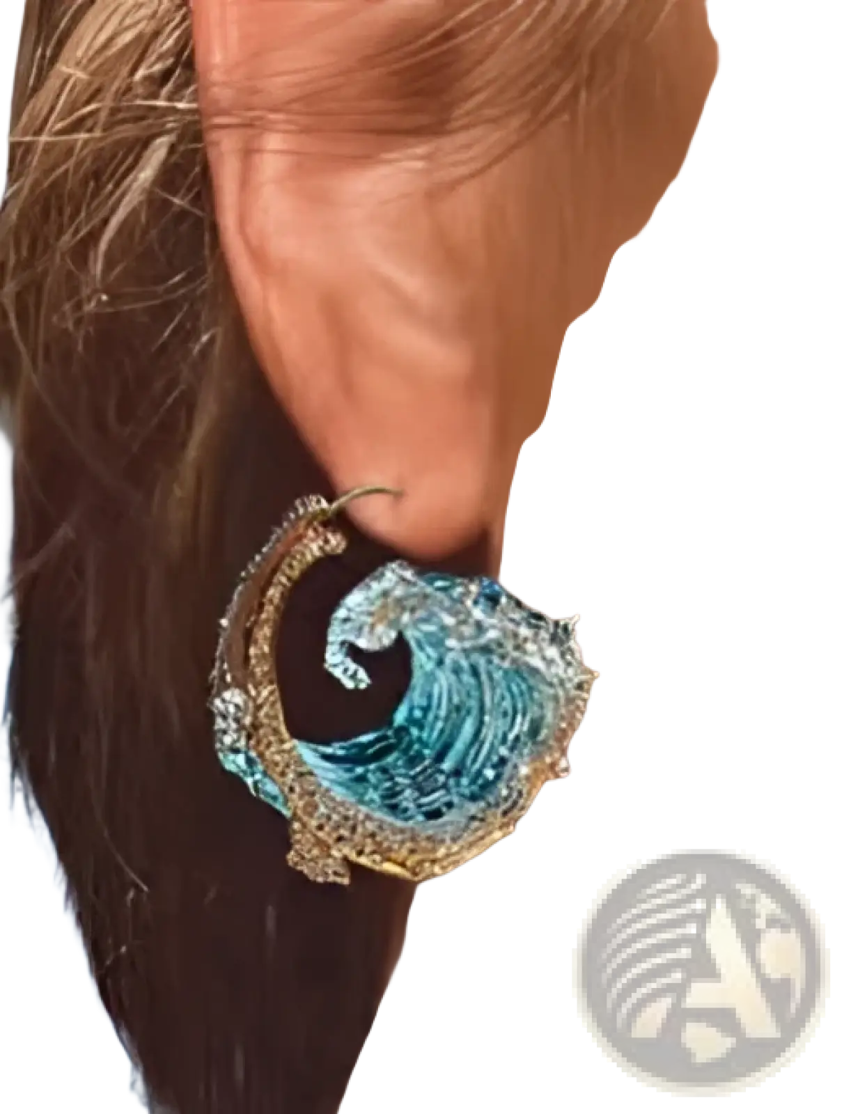 A shimmering blue and gold wave-shaped earring with intricate detailing matching ocean wave turquoise glass pendant necklace