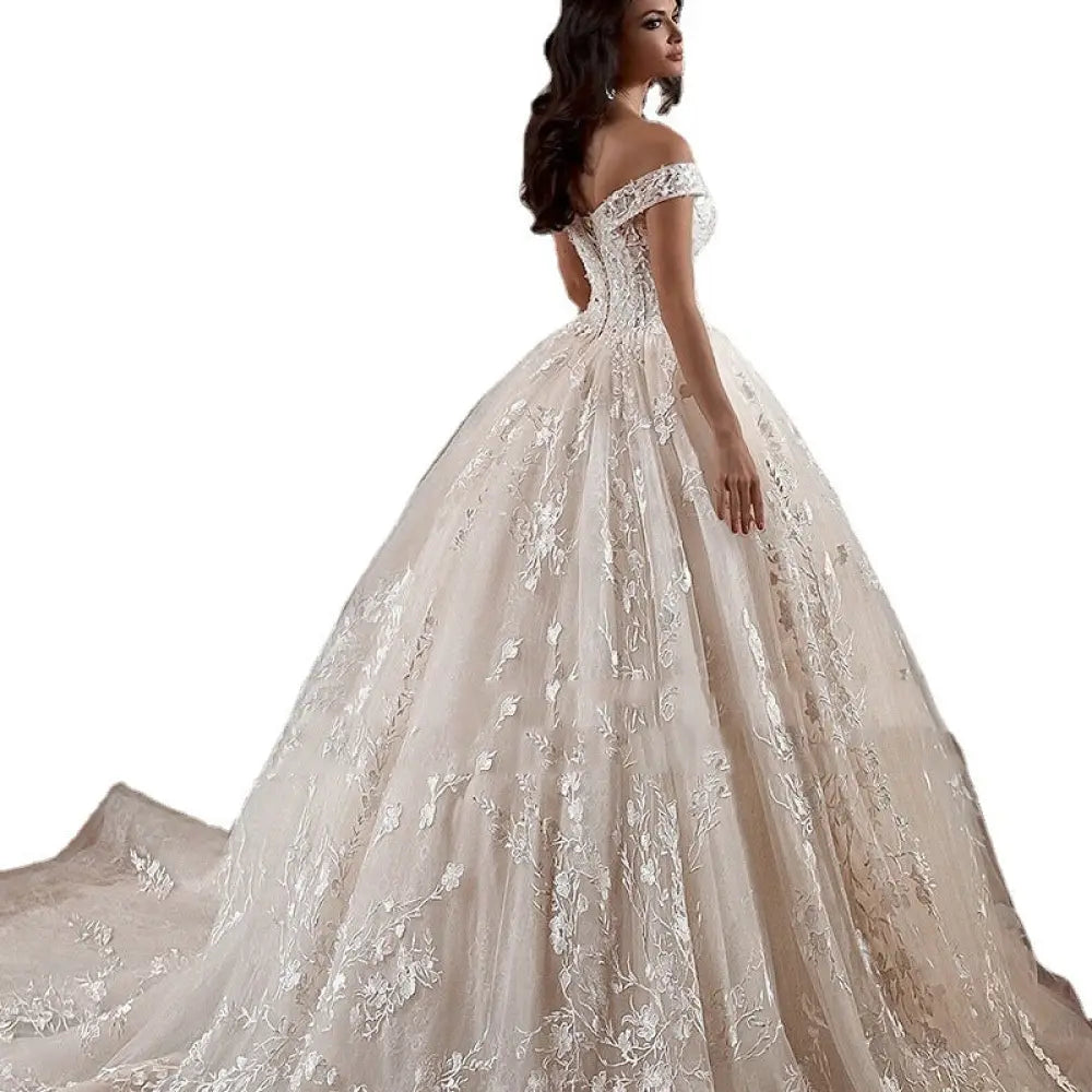 Ivory off-shoulder lace wedding gown with intricate floral embroidery and voluminous skirt by French Mori