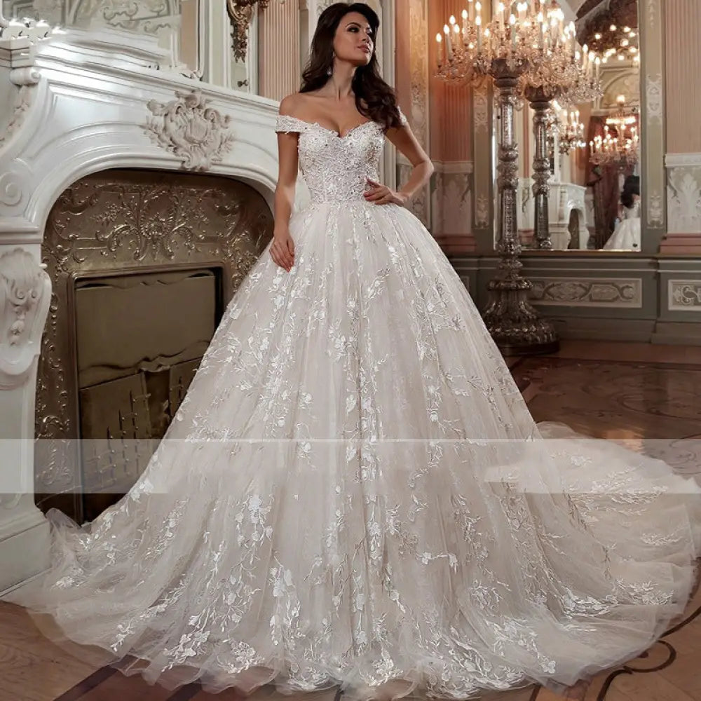 A stunning ivory lace French Mori embroidered off-shoulder wedding dress with floral embroidery and a voluminous tulle skirt