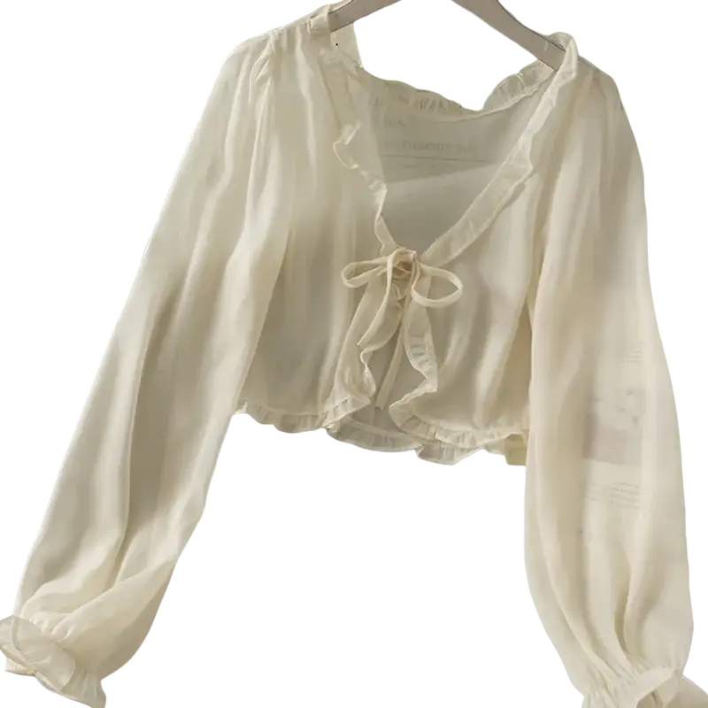 Off-white sheer blouse with long sleeves ruffled neckline hemline and soft tied bow featuring open stitch design