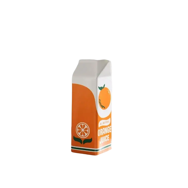 A vibrant orange juice carton ceramic vase with a white top green accents and an illustrated orange slice design