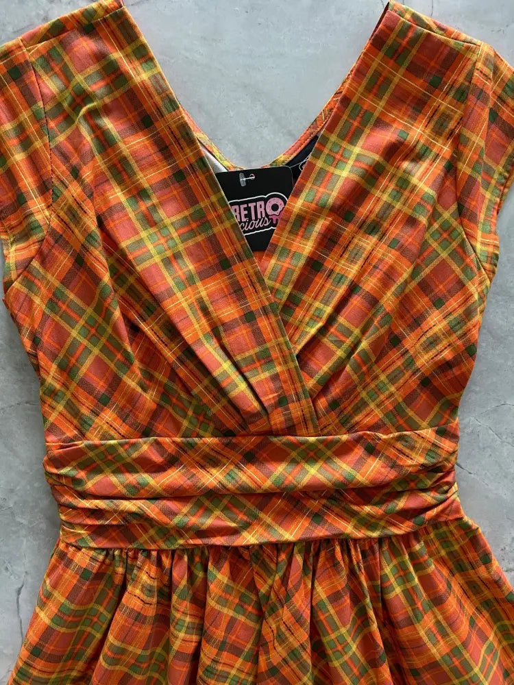 Orange plaid Greta v-neck cotton dress with pockets featuring a vibrant orange green and yellow plaid pattern and gathered waistband