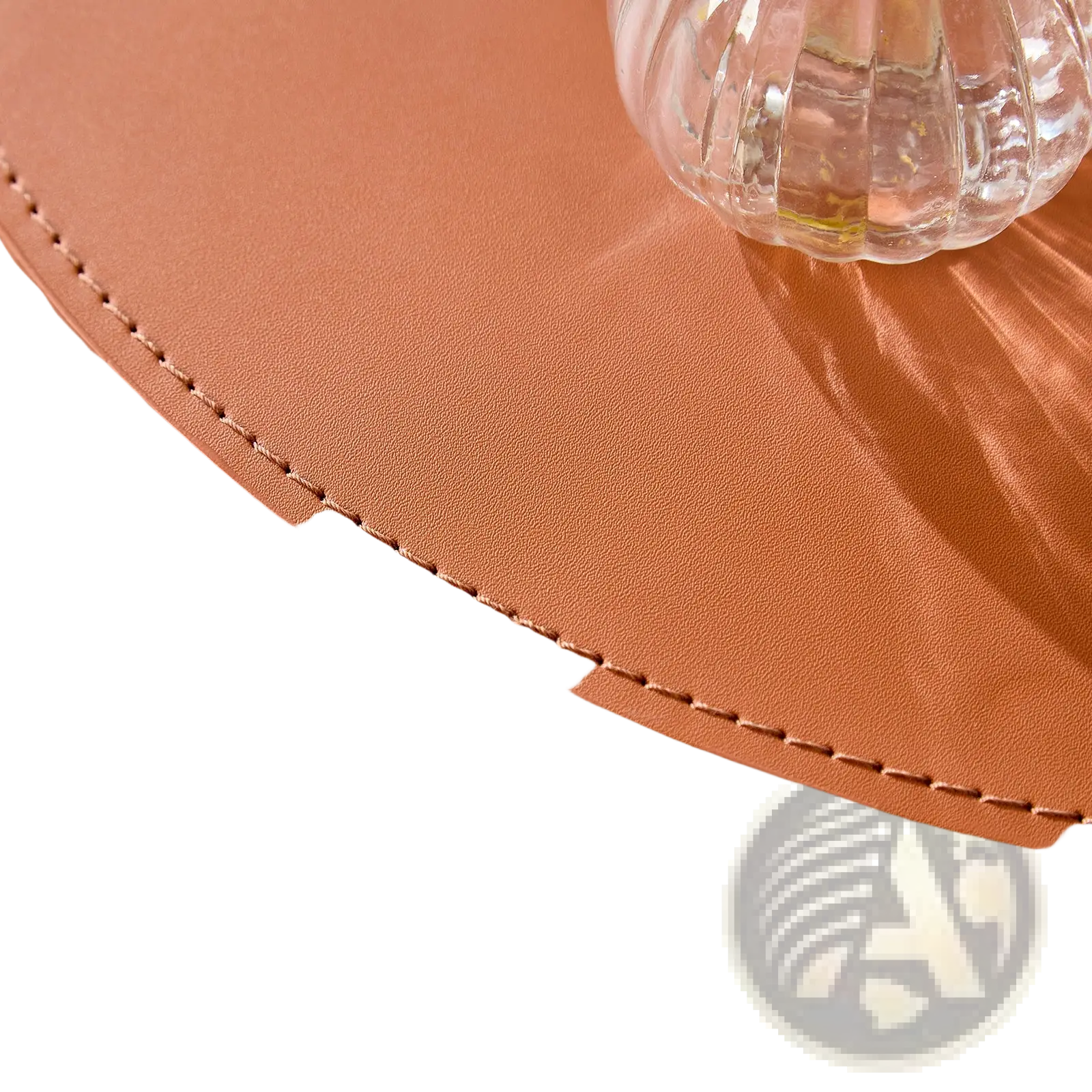 Tan leather bucket with curved top and precise stitching along rim from orange saddle leather round coffee table set