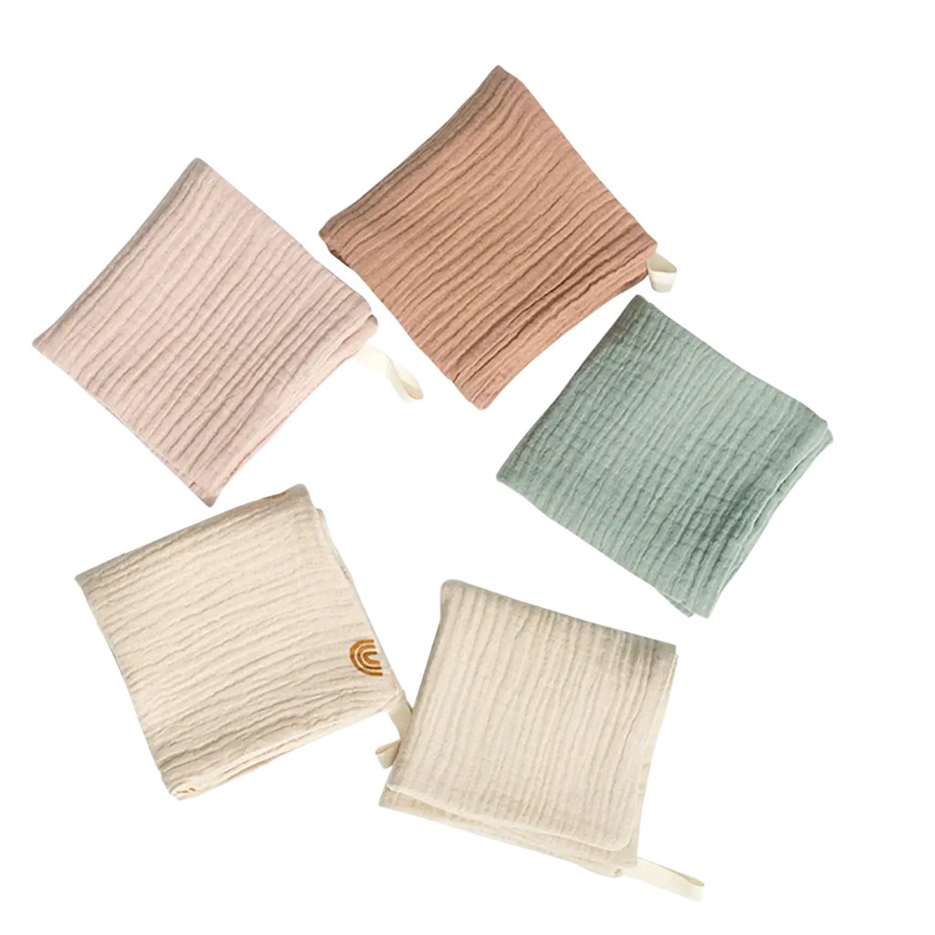 Organic cotton baby bath towel and muslin set in soft pastel colors with subtle ribbed texture and small fabric ties