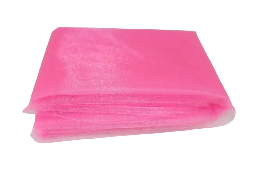 A stack of vibrant pink tulle fabric softly folded in an organza fabric 70cm width diy decor roll