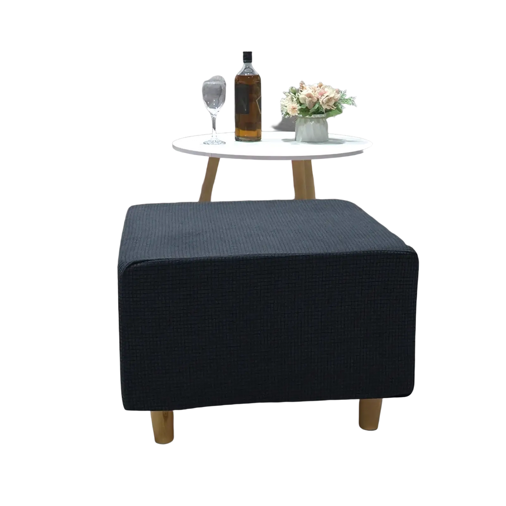 Navy blue textured fabric ottoman with light wood legs featuring a stretch elastic slipcover for footrest protection