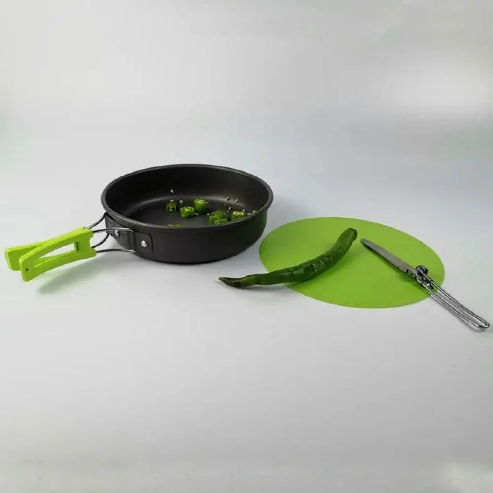 Black frying pan with bright green handle and detachable wire loop featuring non-stick interior for lightweight camping use