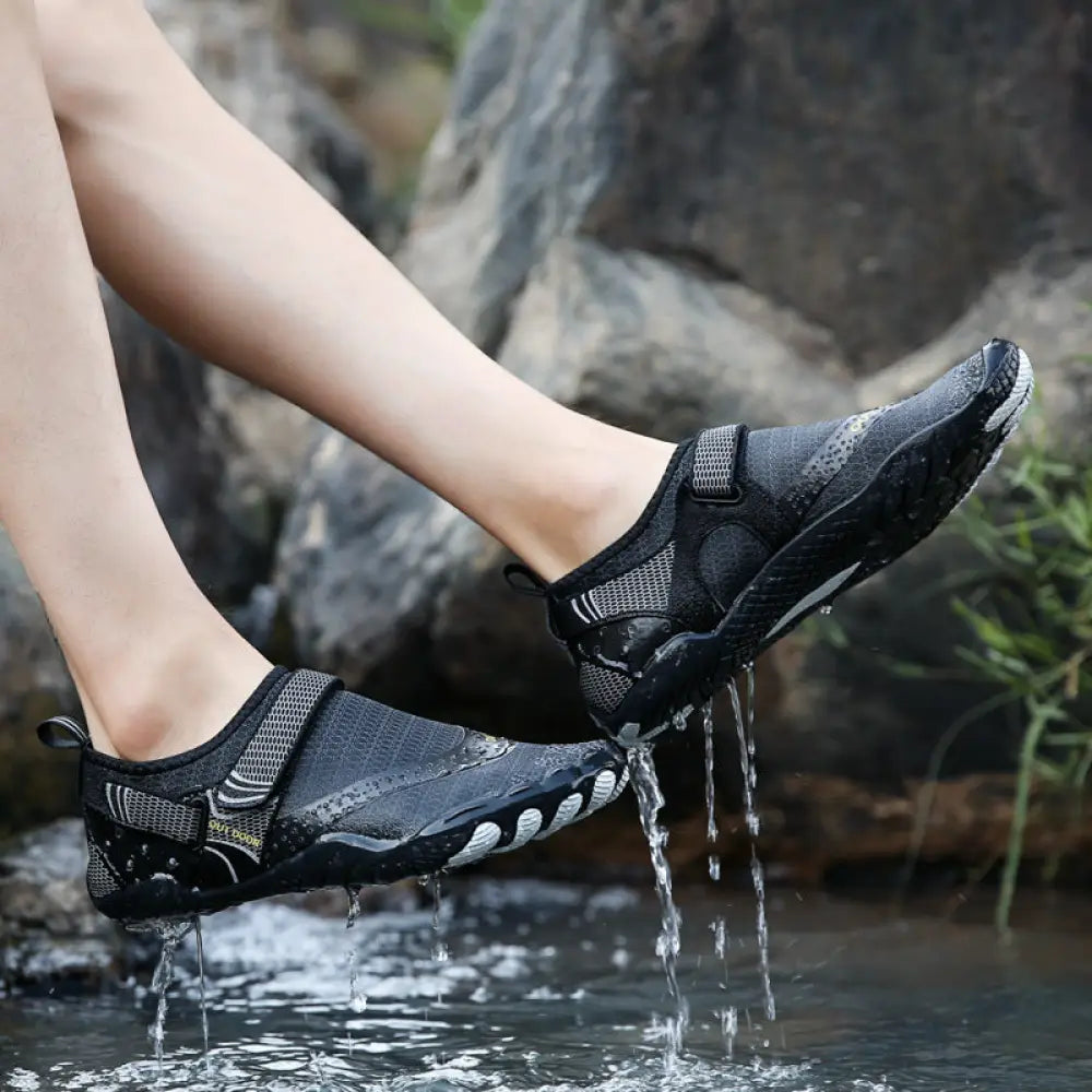 Black lightweight cut resistant five finger outdoor wading shoes with mesh and rubber details for wet environments