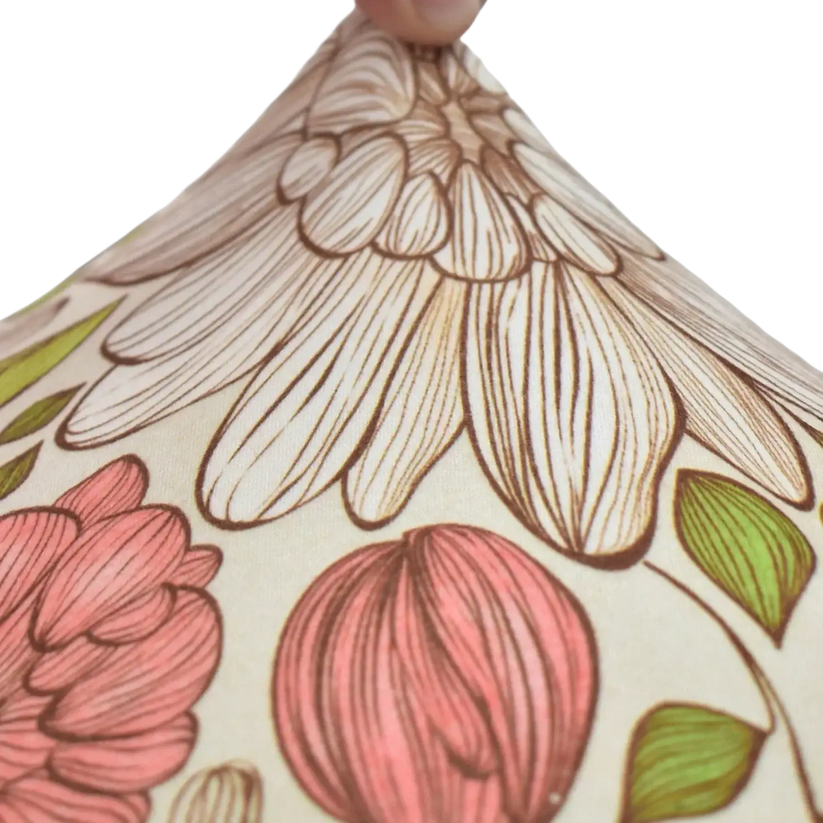 A cream-colored fabric lampshade with floral pink blossoms and green leaves complementing outdoor patio sofa cushions