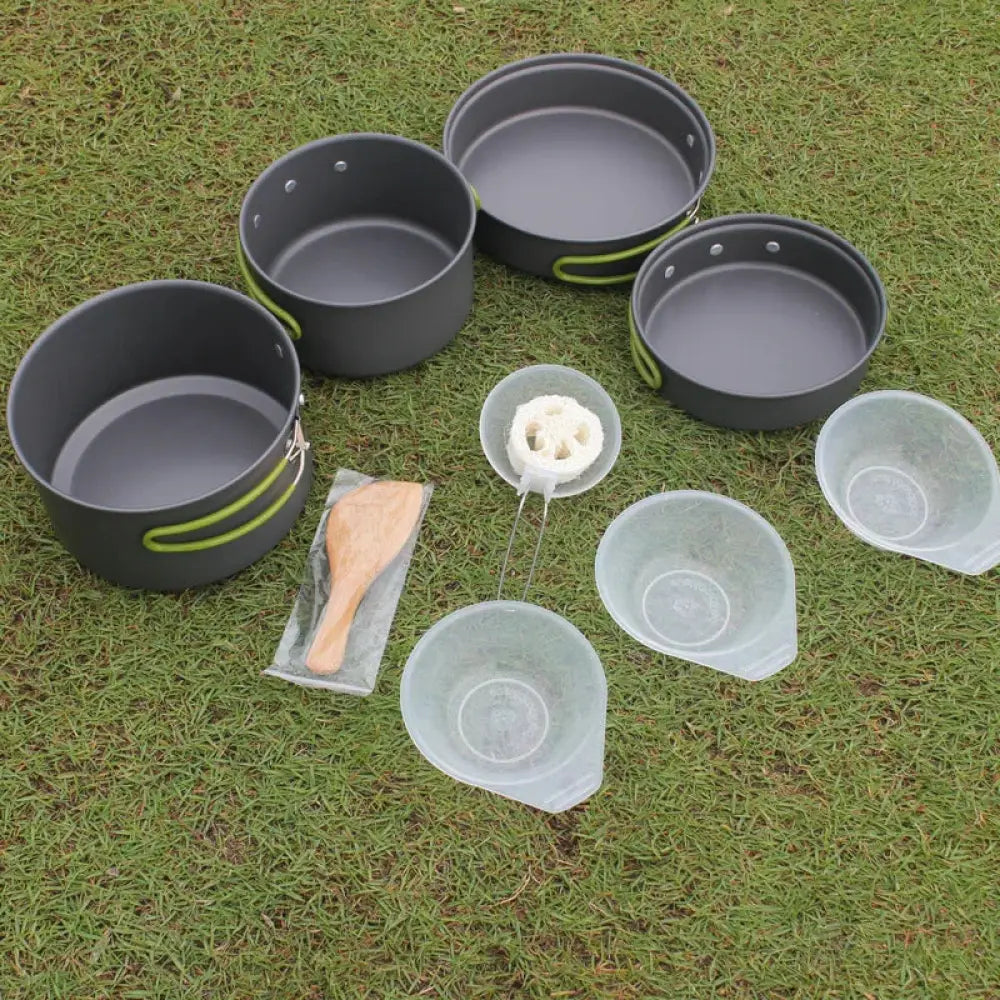 Set of four black aluminum non stick camping pots with lime green handles and wooden spoon in arbaglobal cookware set packaging