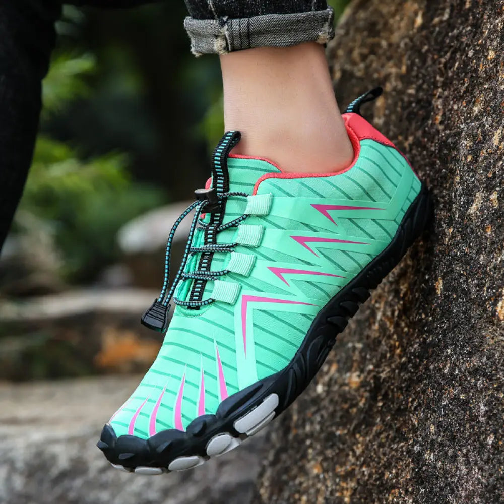 A vibrant mint green and pink breathable five finger quick dry water sports shoe with black laces and geometric patterns