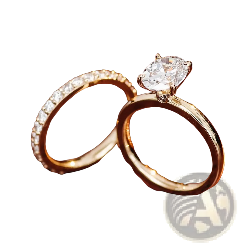 A gold oval lab diamond bridal set featuring an oval-cut diamond ring with four prongs and a diamond-accented band