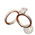 A gold oval lab diamond bridal set featuring an oval-cut diamond ring with four prongs and a diamond-accented band