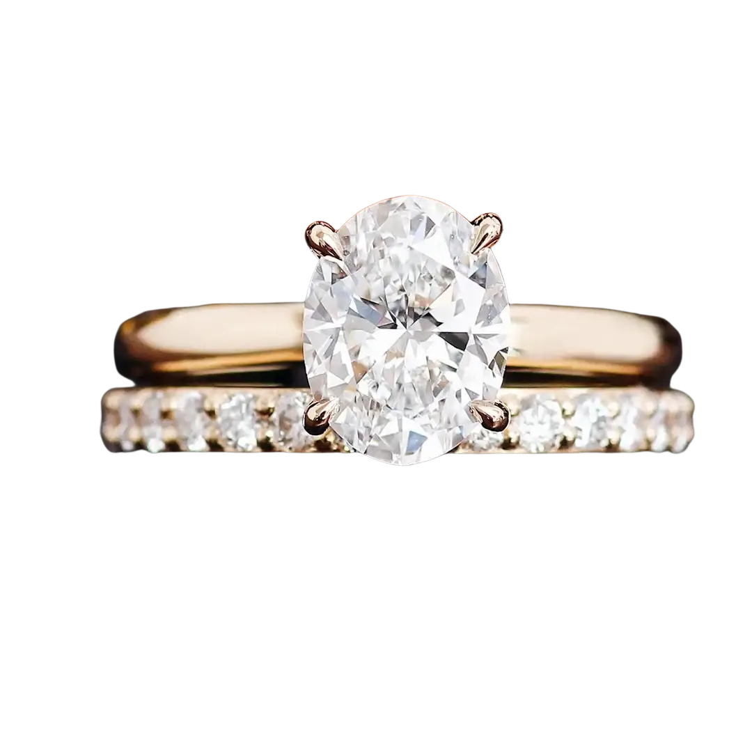 A radiant oval lab diamond bridal set in yellow gold featuring an engagement ring and pave diamond wedding band