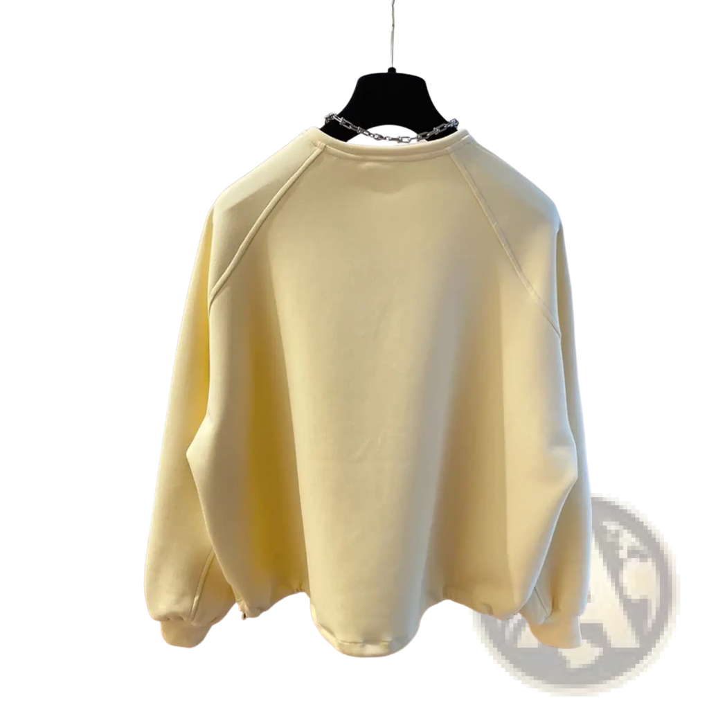 Oversized cream soft cotton hoodie with raglan sleeves and chain necklace detail at the neckline