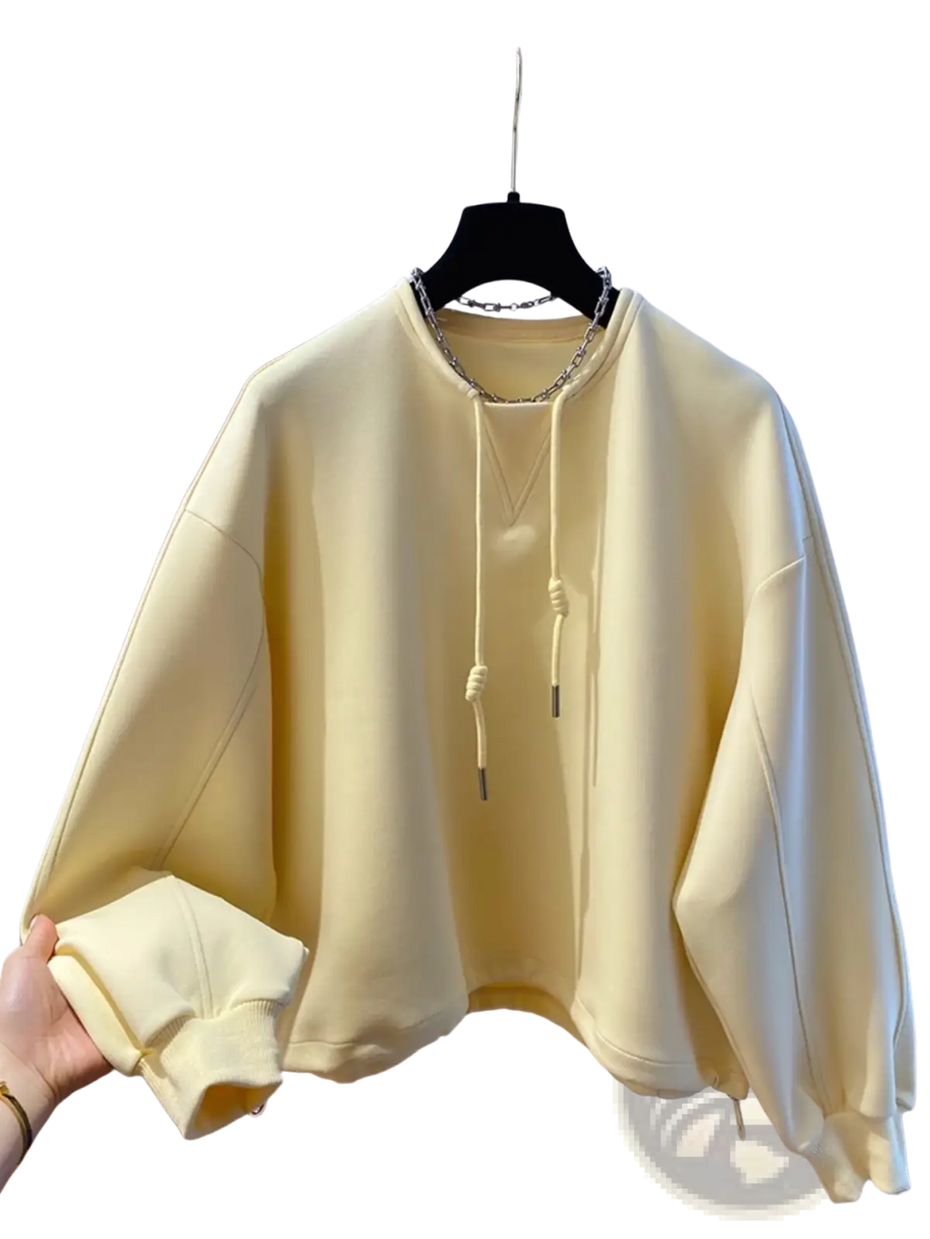 Oversized cream hoodie with chain detail soft pastel yellow fabric drawstring hood and ribbed cuffs on black hanger