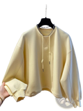 Oversized cream hoodie with chain detail soft pastel yellow fabric drawstring hood and ribbed cuffs on black hanger
