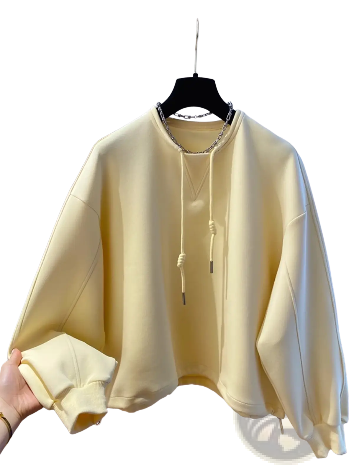 Oversized cream hoodie with chain detail soft pastel yellow fabric drawstring hood and ribbed cuffs on black hanger