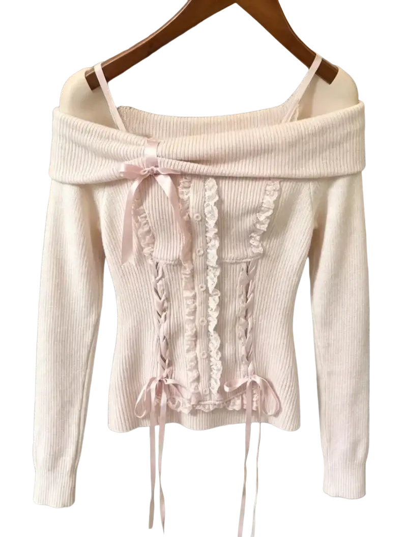 A delicate oversized knit sweater in soft blush pink with ribbed texture lace detailing and satin ribbon ties for winter wear