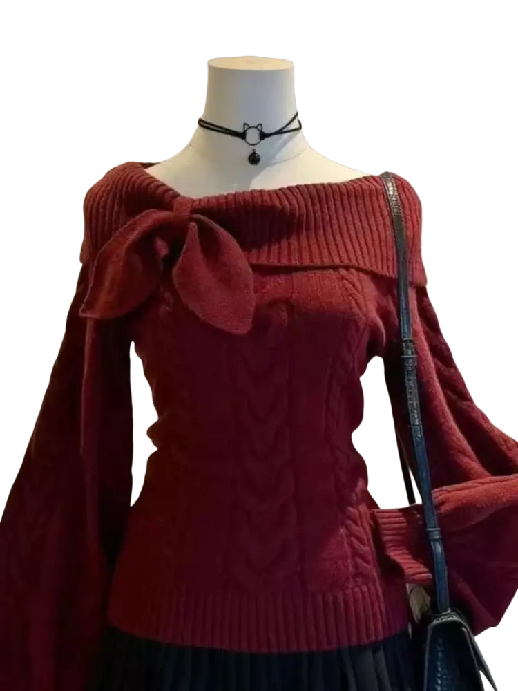 A rich burgundy oversized cable-knit sweater with a bow shoulder detail long sleeves and off-the-shoulder neckline