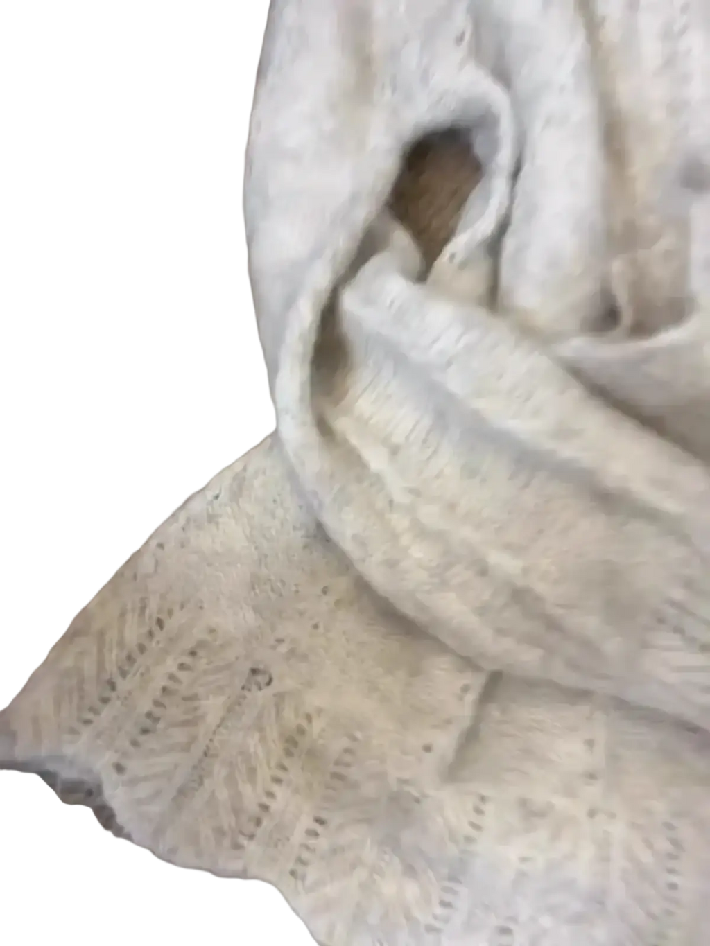 A soft off-white knitted scarf with delicate lace pattern and scalloped edge paired with oversized knit sweater
