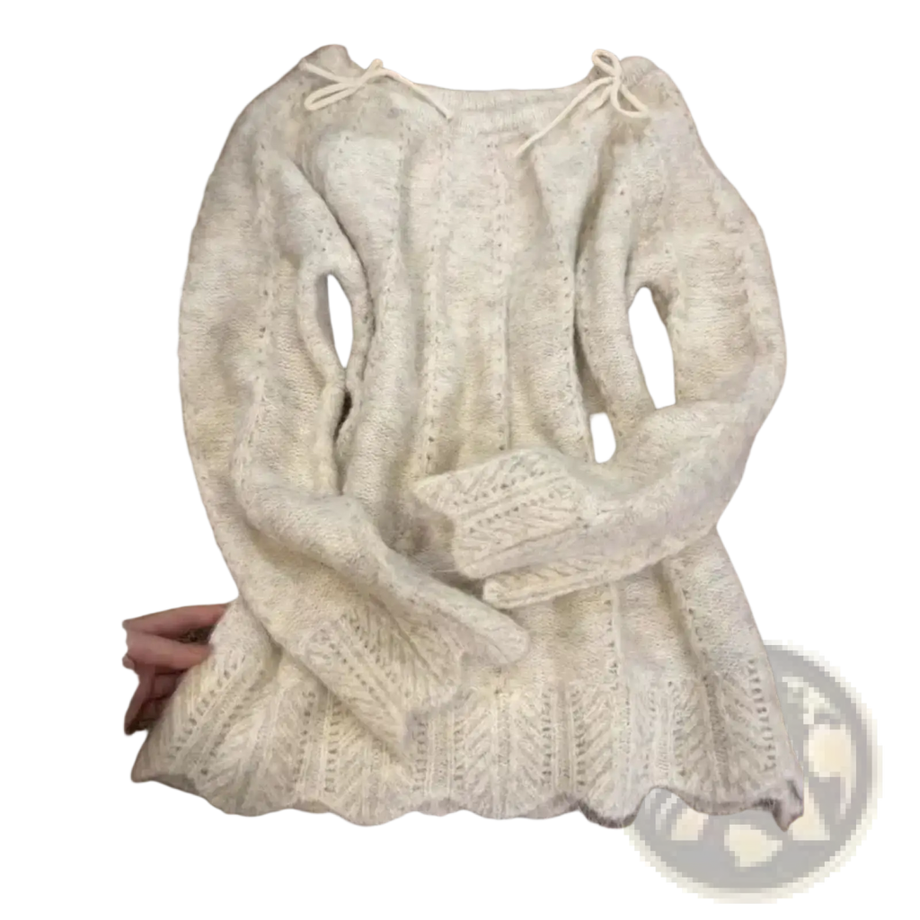 A soft off-white oversized knit sweater with intricate cable and lace patterns and drawstrings at the neckline for winter